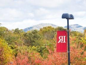 An LR banner hangs from a lamppost outside with the mountains in the background